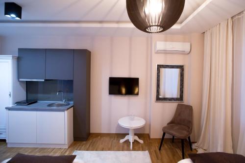 a kitchen with a sink and a table in a room at Apartment Exclusive and Studio in Subotica