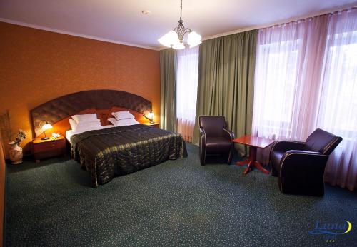 a hotel room with a bed and two chairs at Luna Hotel in Chişinău