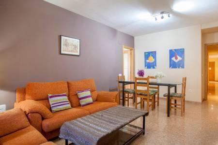 ein Wohnzimmer mit einem Sofa und einem Tisch in der Unterkunft Apartamento Cerca De Valencia in Riba-roja de Túria