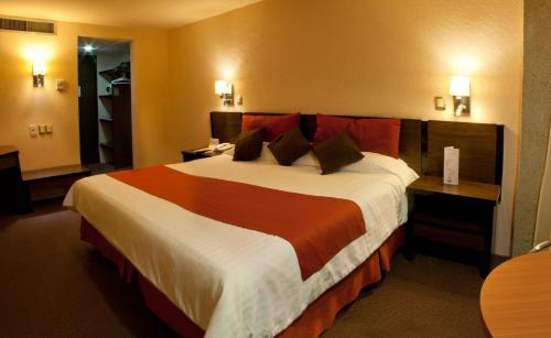 - une chambre avec un grand lit dans une chambre d'hôtel dans l'établissement Hotel Real Plaza, à San Luis Potosí