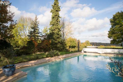 a swimming pool in a yard with trees at Domaine du Merlot in Sainte-Sabine