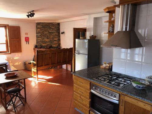 a kitchen with a stove and a refrigerator at Casa da Ponte Rio de Onor in Bragança