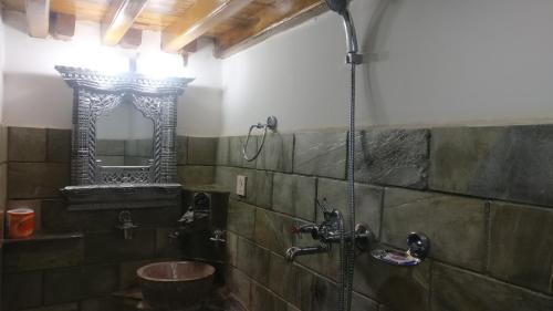 a bathroom with a shower with a sink and a mirror at Temple House in Kathmandu