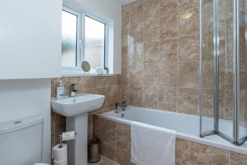 a bathroom with a bath tub and a sink at Milton House in Plymouth