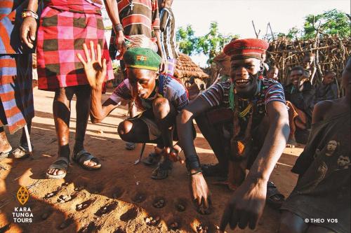 a group of people standing around a man in the dirt at Kara-Tunga Safari Camp in Moroto