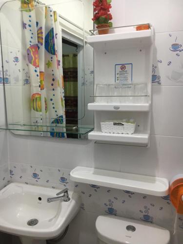 a bathroom with a sink and a toilet and a mirror at บุญจินดา รีสอร์ท in Ban Phayom