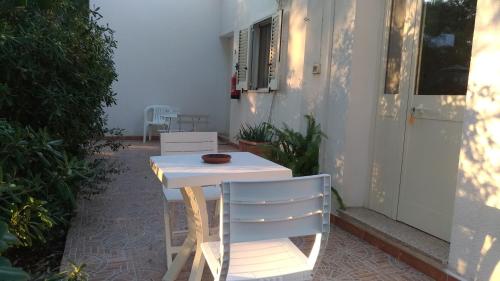 un tavolo bianco e una sedia su un patio di Agriturismo Palese a Torre San Giovanni Ugento