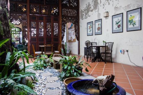 a room with a fountain and plants and a table at Carnarvon House in George Town