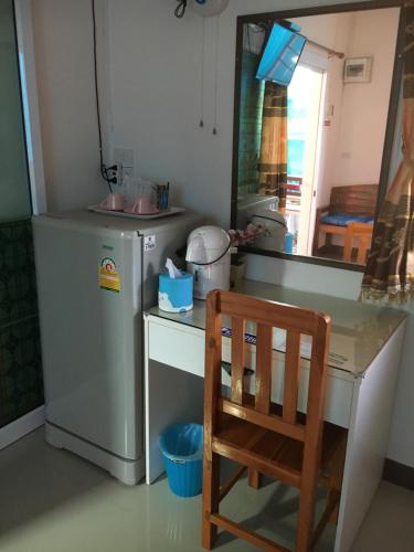 a kitchen with a desk and a refrigerator and a chair at บุญจินดา รีสอร์ท in Ban Phayom