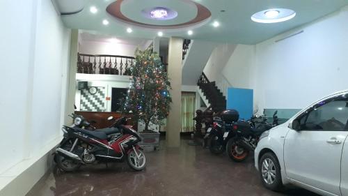 una stanza con moto e un albero di Natale dentro di Nhà nghỉ Book a Hoàn Giáp