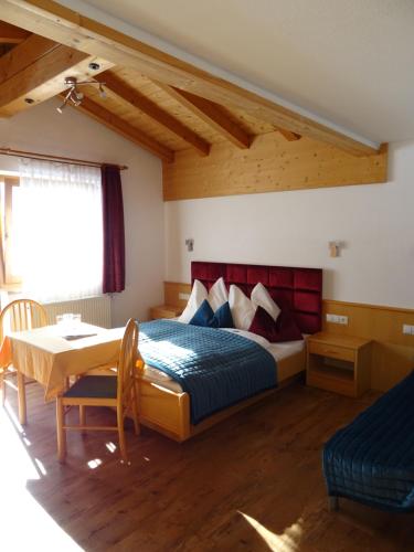 sypialnia z łóżkiem i stołem w pokoju w obiekcie Hotel Restaurant Rosengarten w mieście Zell am Ziller