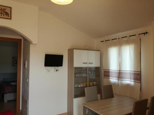 a dining room with a table and a tv at Apartment Altomare in Cala Gonone