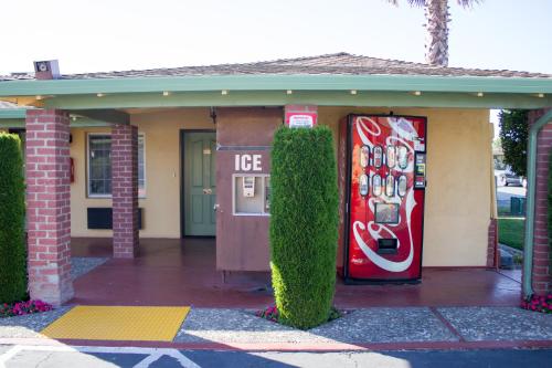a house with a coke machine in front of it at King's Rest Motel in Gilroy