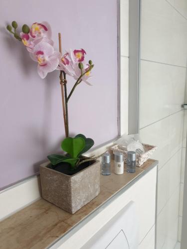 eine Vase mit Blumen auf einer Theke im Bad in der Unterkunft Gasthaus Zum Rebstock in Hirzenach