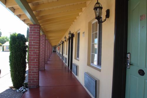 an empty hallway of a building with awning and a door at King's Rest Motel in Gilroy