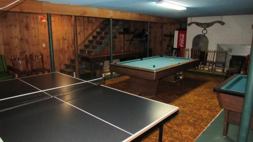 a room with a pool table and a staircase at Carlson's Lodge in Twin Mountain