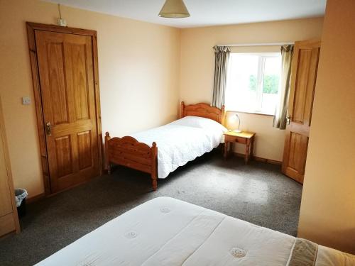 una camera da letto con due letti e una finestra di Danubio Guest Accommodation a Doonbeg