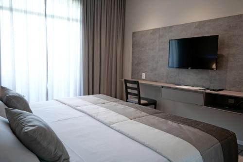 a hotel room with a bed and a flat screen tv at Blue Tree Premium São Luis in São Luís