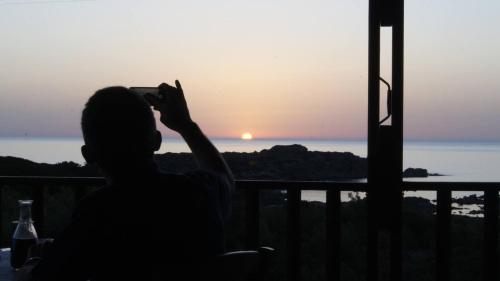 a person taking a picture of the sunset at Glykeria Hotel in Elafonisi