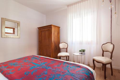 a bedroom with a bed and two chairs and a window at Laguna Boutique Apartments in Mestre