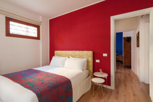a bedroom with a red wall and a bed at Laguna Boutique Apartments in Mestre