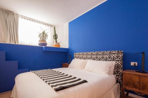 a blue bedroom with a bed with a blue wall at Laguna Boutique Apartments in Mestre