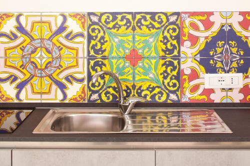 a kitchen sink with a colorful tile wall at Laguna Boutique Apartments in Mestre
