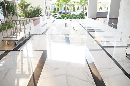 a lobby with white marble floors and gold chairs at SN Connx - SHA Plus in Pattaya Central