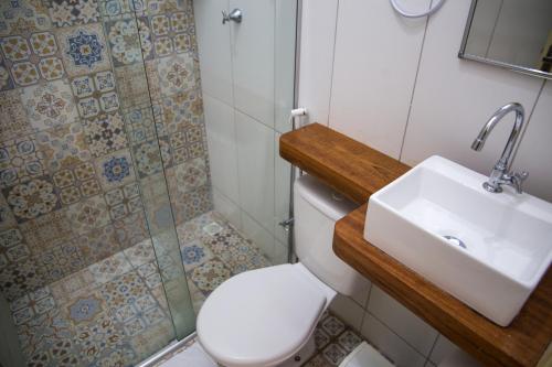a bathroom with a sink and a toilet and a shower at Pousada Meraki Beach in Maragogi