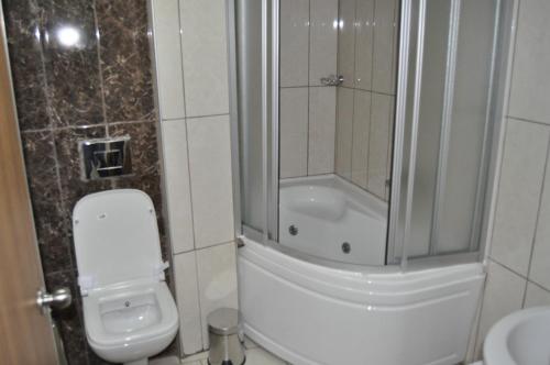 a bathroom with a shower and a toilet and a sink at Garra Hotel in Konya