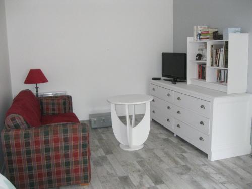 紹維尼的住宿－LA MAISON D'HENRI，客厅配有沙发和带电视的梳妆台。