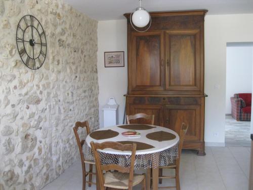 uma sala de jantar com mesa e cadeiras e um relógio em LA MAISON D'HENRI em Chauvigny
