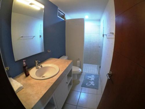 a bathroom with a sink and a toilet and a mirror at 3 Bedroom Apartment at La Joya Hotel Zone in Puerto Vallarta