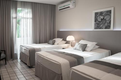 a hotel room with two beds and a window at Blue Tree Premium São Luis in São Luís