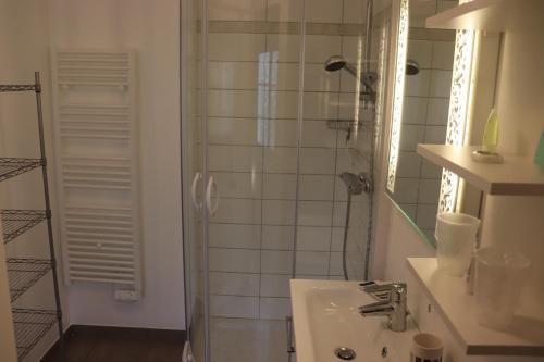 a white bathroom with a shower and a sink at Villa des sables avec 1 studio pour 2 personnes pouvant être complété par une chambre avec sa salle de bain et WC si 4 personnes in Cabourg