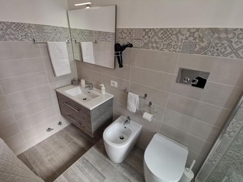 een badkamer met een toilet, een wastafel en een spiegel bij SUPER panorama & Astonishing apartment seaview in Giardini Naxos