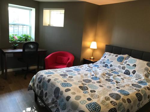 a bedroom with a bed and a red chair at STEPS to CONVENTION CENTER, DOWNTOWN DC, METRO STATION: PRIVATE APARTMENT in Washington, D.C.