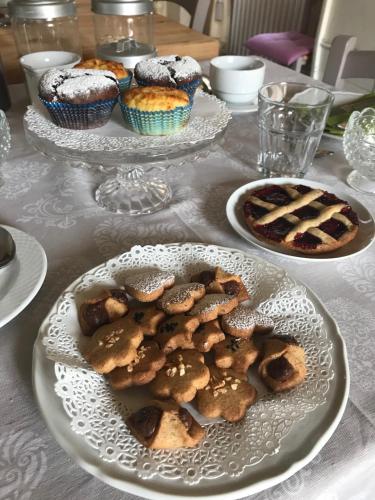 Casa Aloe B&B في مونتي سان سافينو: طاولة مغطاة بأطباق من البسكويت والكعك