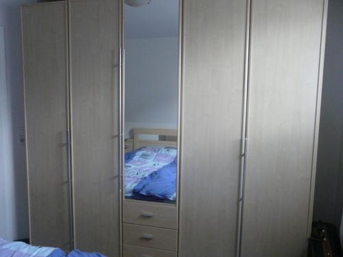 1 dormitorio con cama y armario con espejo en 44 Kliffstraße, en Ostseebad Nienhagen