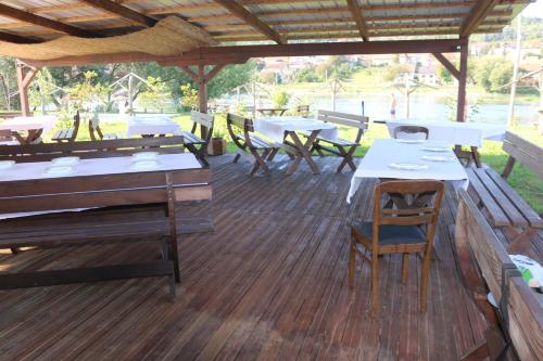 a patio with tables and chairs on a wooden deck at Holiday homes Piralo in Kostajnica
