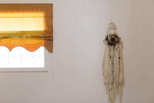 a scarecrow hanging on a wall next to a window at Koronisia Apartments in Koronisia