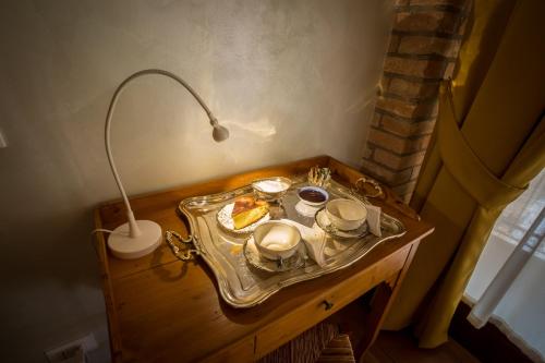 een tafel met een dienblad met eten en een lamp erop bij Barchessa Da Rio in Ponte San Nicolo