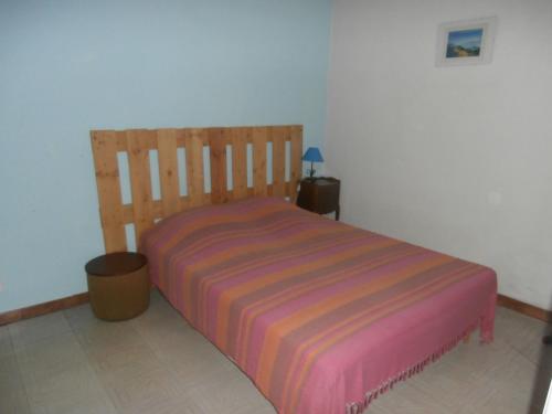 une chambre avec un lit avec une couverture rayée dans l'établissement Le Claux des Hespérides, à Allemagne-en-Provence