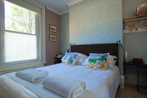 Un dormitorio con una cama blanca con toallas. en Number One B&B en Deal