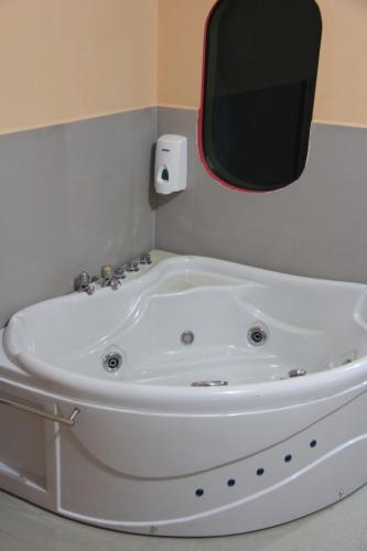 a white bath tub in a bathroom with a window at Hotel Platinum Class in Nueva Loja