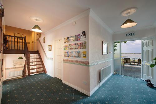 a hallway with a staircase and a stair case at The Waterfront House Country Home in Oughterard