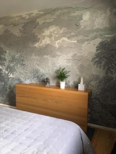- une chambre avec un lit et une peinture de nuages dans l'établissement B&B Les Hauts d'Ornans, à Ornans