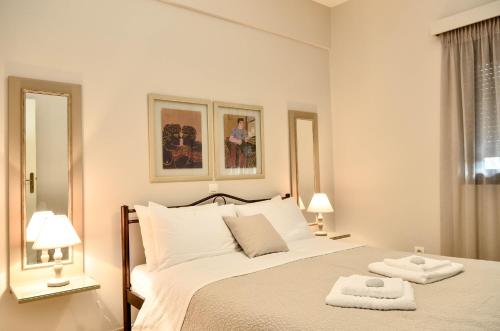 een witte slaapkamer met een bed met twee handdoeken erop bij Sunrays housing in Kalamata