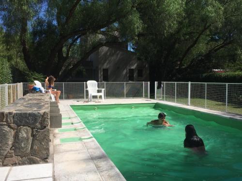 un grupo de personas nadando en una piscina en Reina de las Cortaderas en Merlo