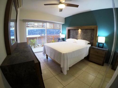 a bedroom with a bed and a large window at 3 Bedroom Apartment at La Joya Hotel Zone in Puerto Vallarta